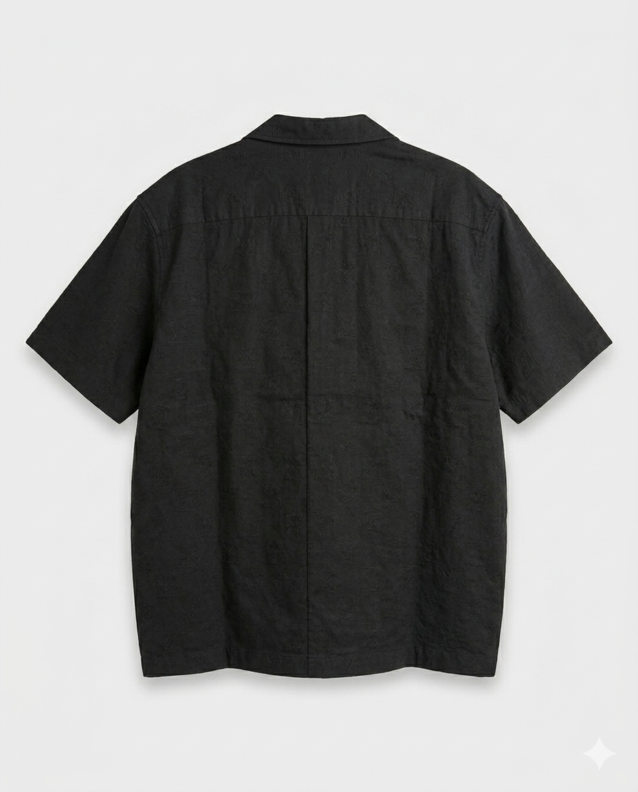 IMG_5819 A sleek black short-sleeve shirt with subtle woven texture and a structured relaxed fit. Minimal, versatile, and elevated with quiet luxury energy.